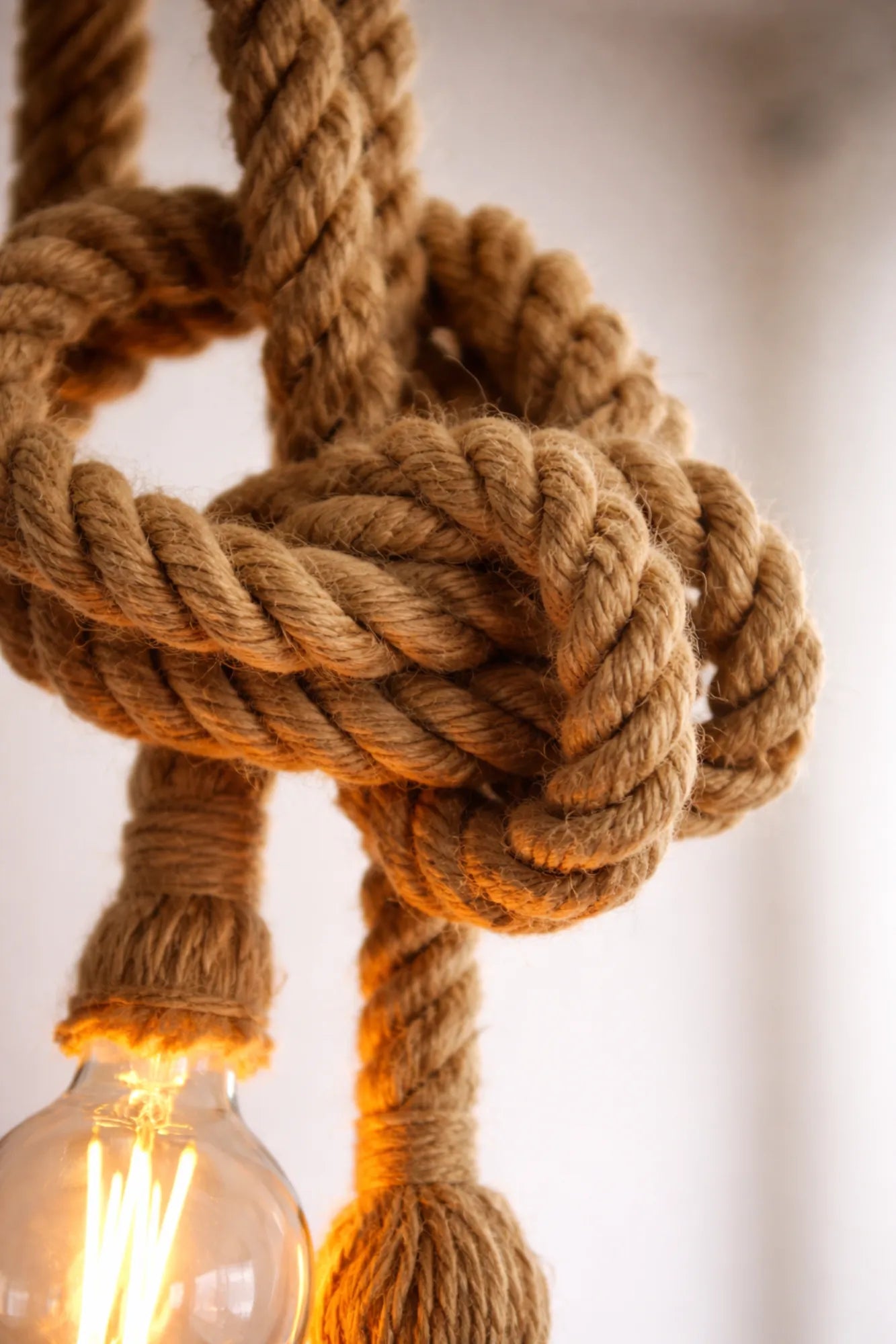 Detail van handgeknoopte jute touwlamp met warme filamentlamp