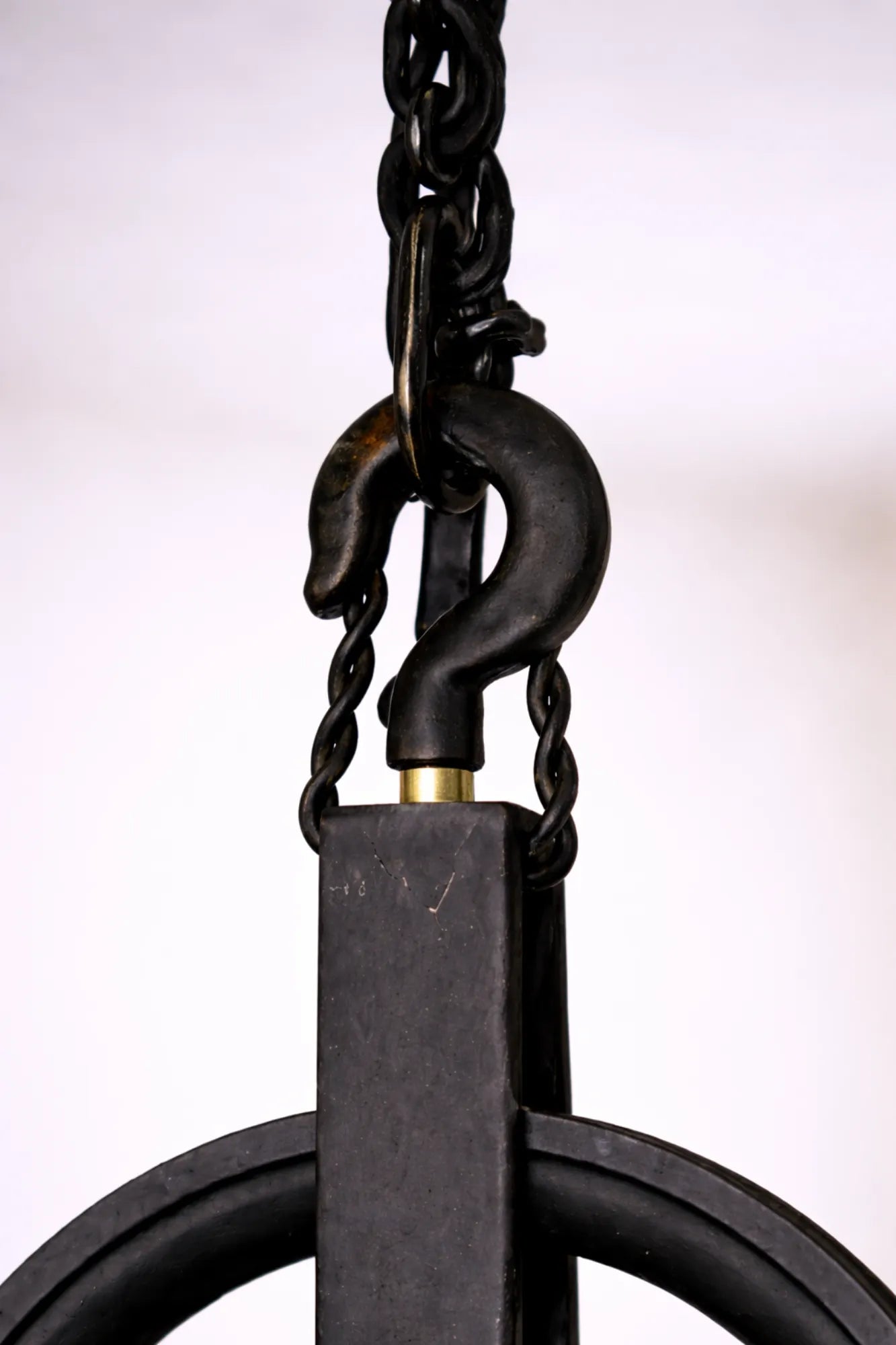 Detail van zwarte metalen haak en ketting van industriële katrol hanglamp