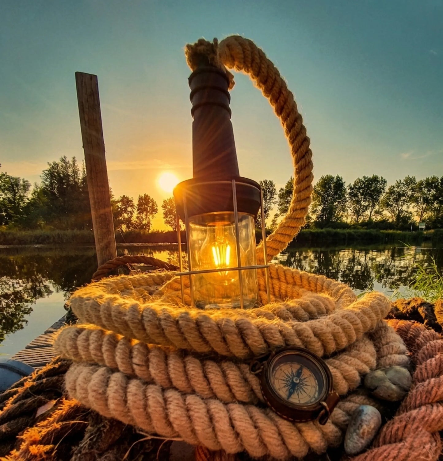industriële nautische buitenlamp met dik jutetouw en zwarte metalen fitting bij het water