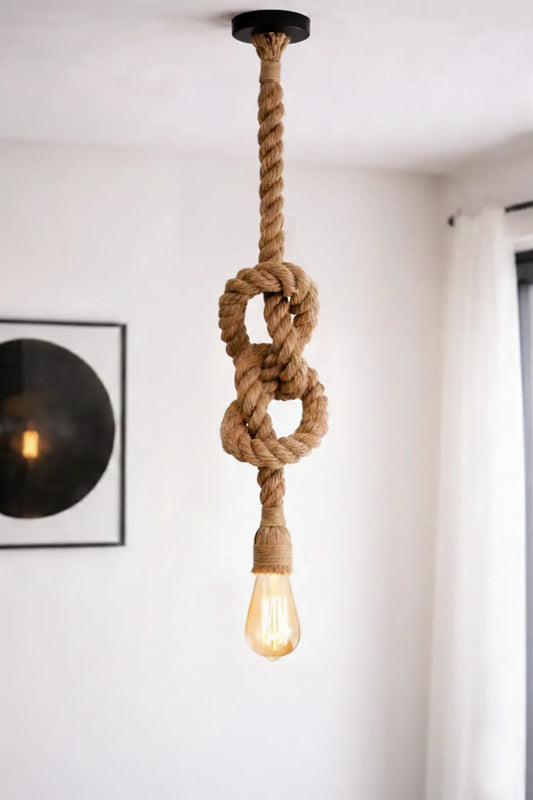 Handgemaakte industriële touwlamp met enkele fitting van jutetouw in een lichte, minimalistische woonkamer