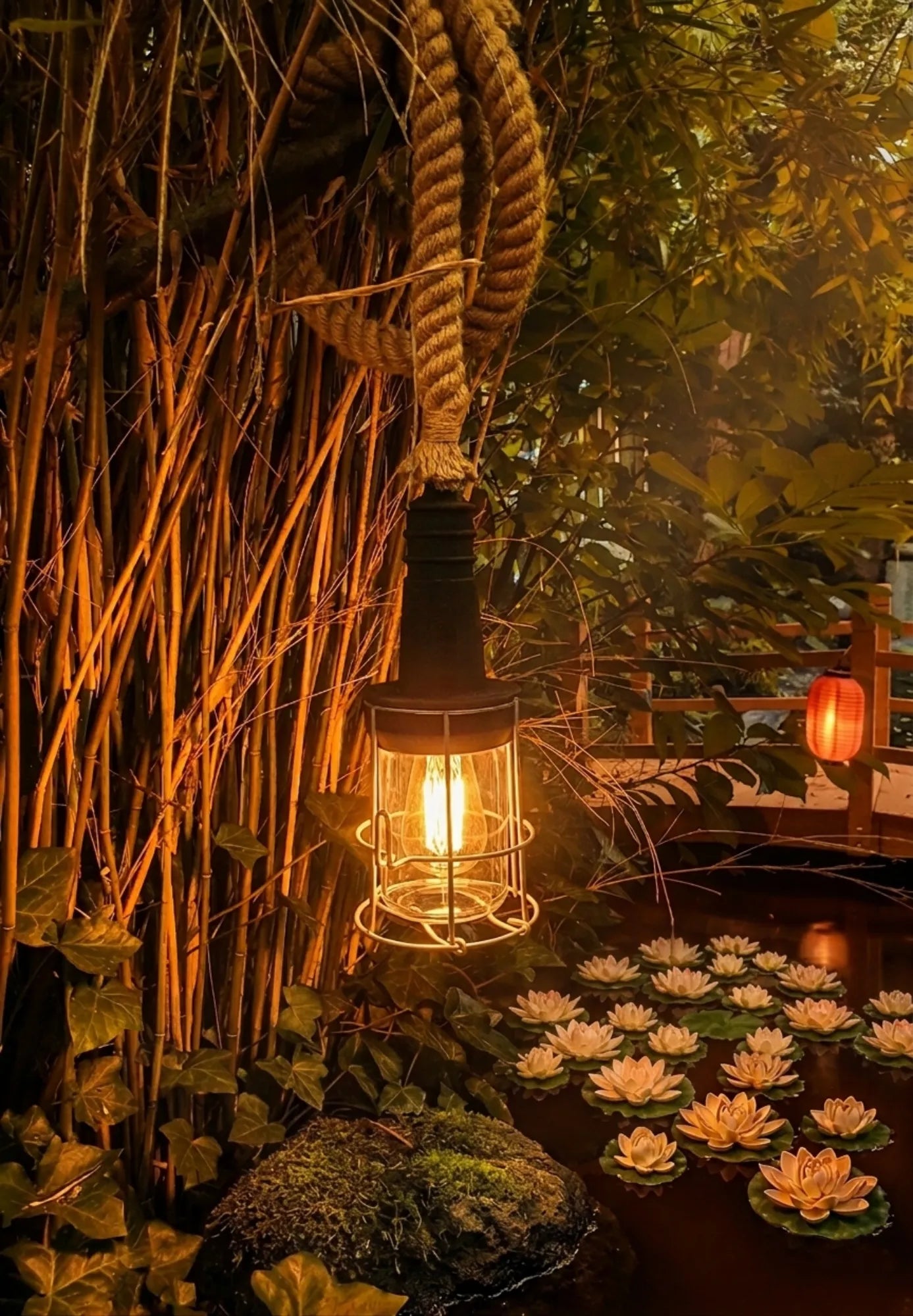 industriële buitenlamp met dik jutetouw en warme edison lamp bij vijver met waterlelies in sfeervolle tuinomgeving