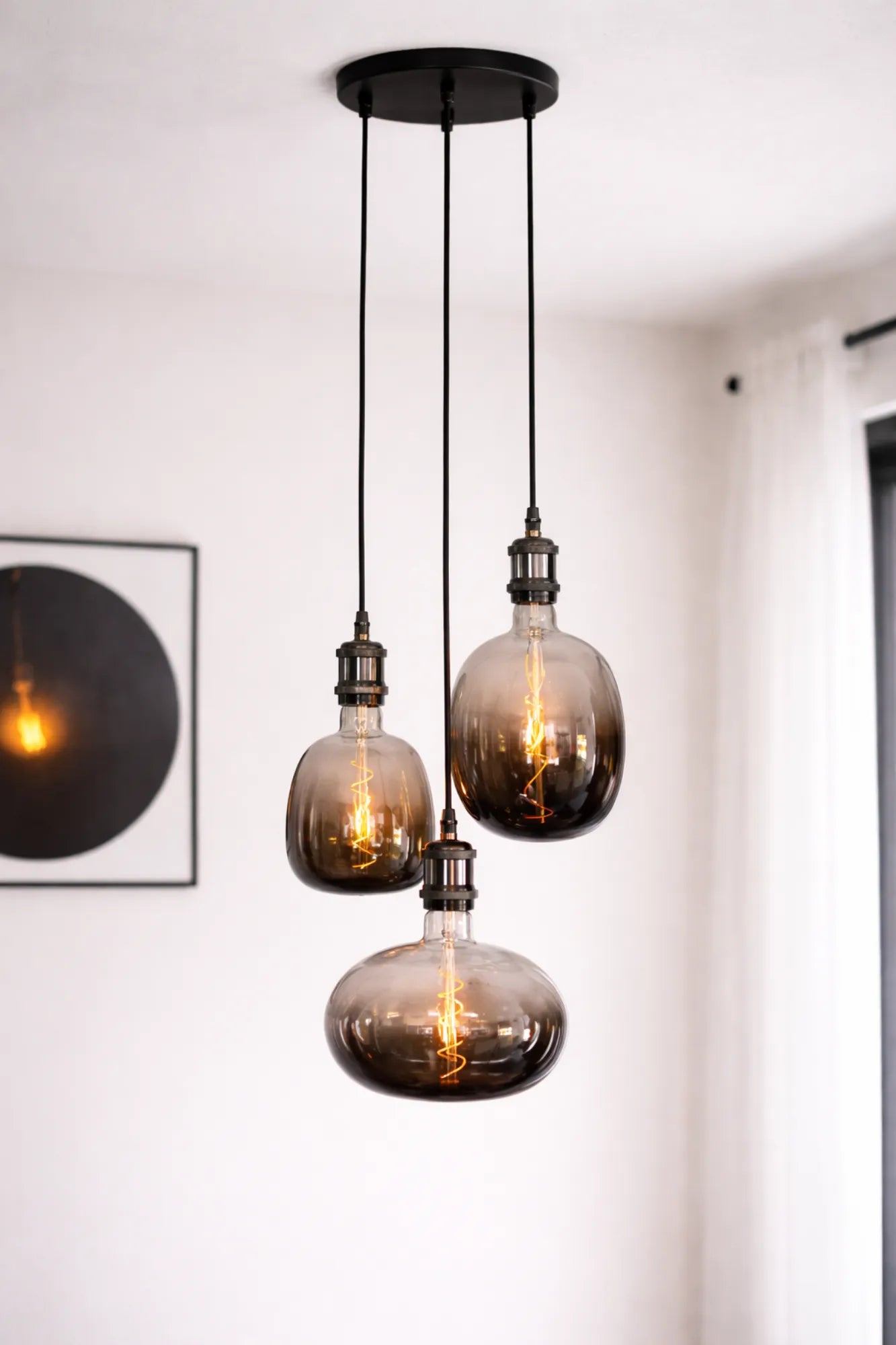 Moonstone industriële hanglamp met drie rookglazen lichtbollen en zwarte plafondplaat, vrijstaand productbeeld.